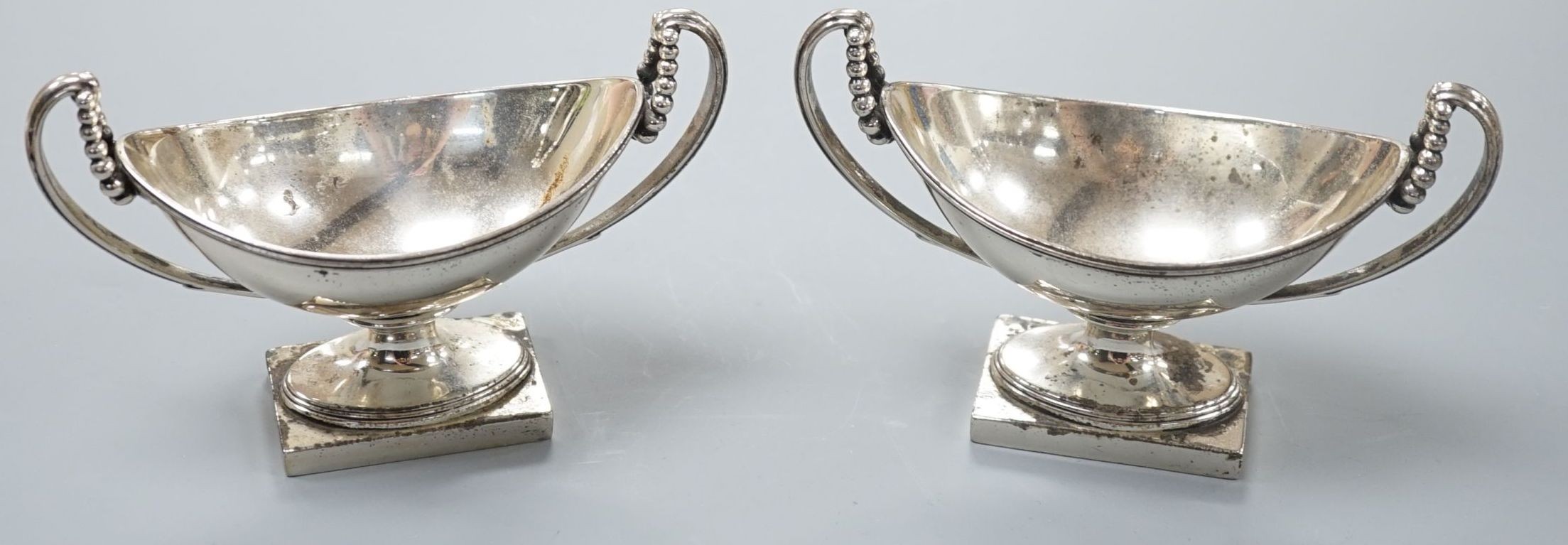 A pair of George III silver boat shaped two handled pedestal salts, Peter Podio, London, 1798, width 31.2cm, 8.5oz.